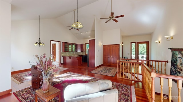 living room featuring dark hardwood / wood-style flooring, high vaulted ceiling, and ceiling fan