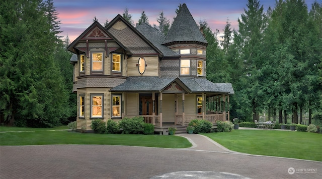 victorian home with a yard and a porch