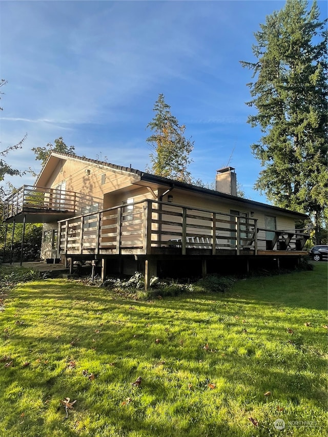 rear view of property with a lawn and a deck