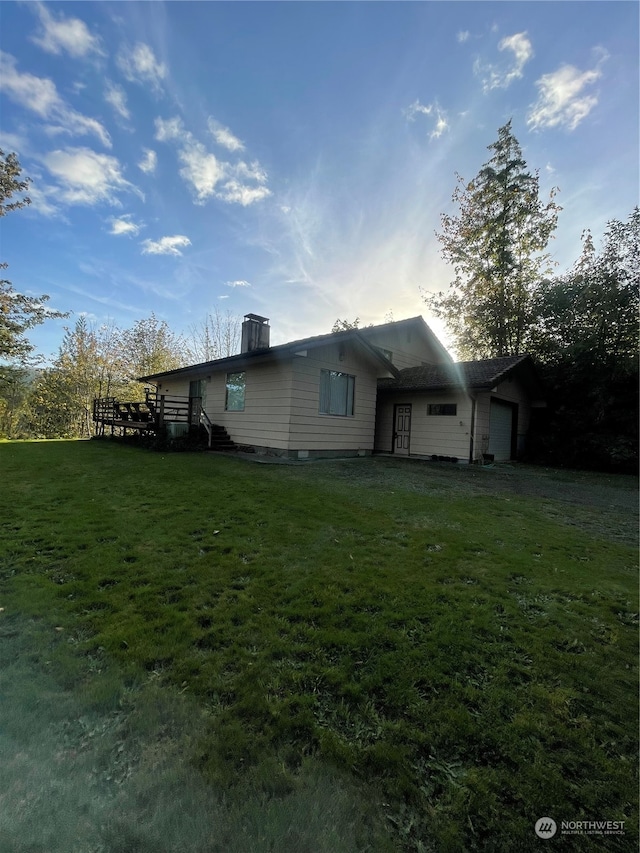 view of side of property with a garage and a lawn