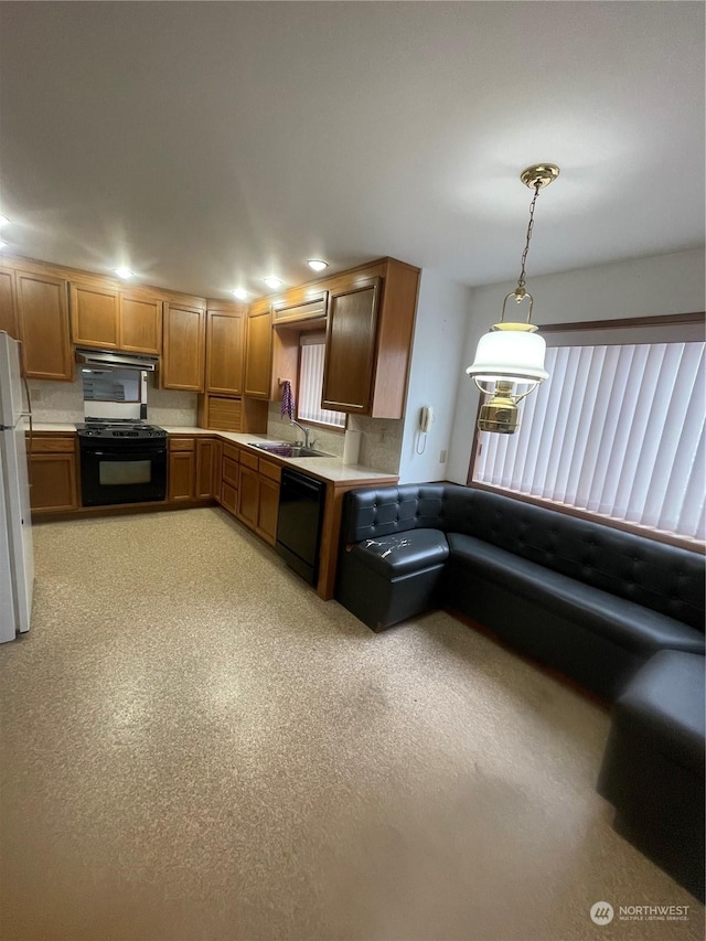 kitchen featuring plenty of natural light, decorative light fixtures, sink, and black appliances