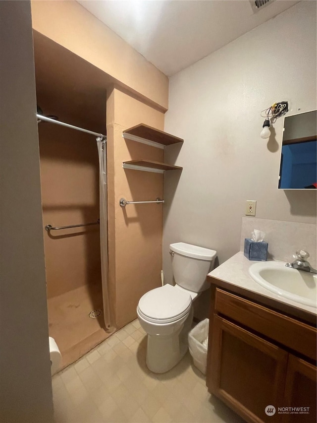 bathroom featuring vanity, toilet, and curtained shower