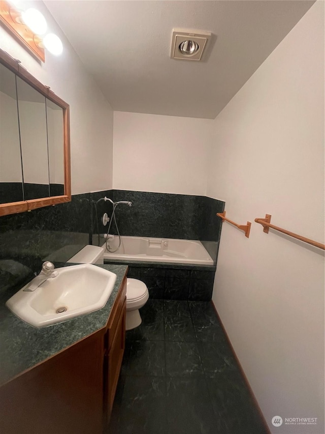 bathroom with vanity, a relaxing tiled tub, and toilet