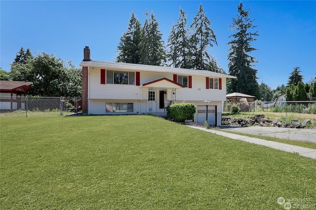 raised ranch featuring a front lawn and a garage