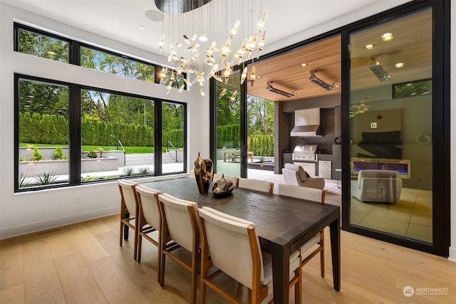 dining room with wooden ceiling, plenty of natural light, light hardwood / wood-style flooring, and a notable chandelier