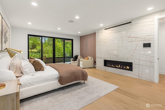 bedroom with light hardwood / wood-style flooring, tile walls, and a tile fireplace