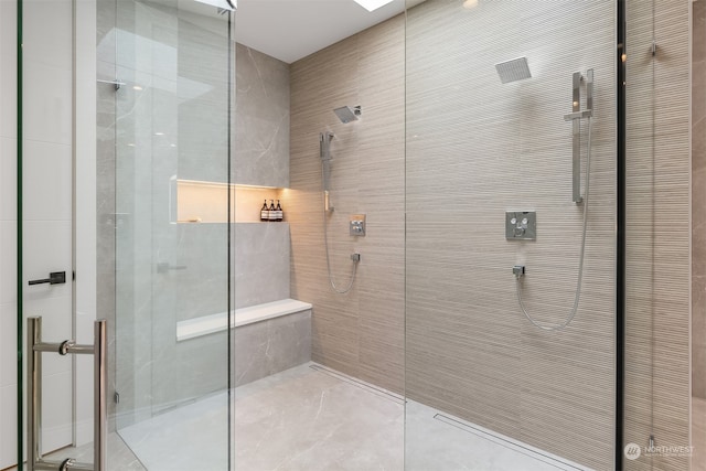 bathroom featuring tile walls and a shower with shower door