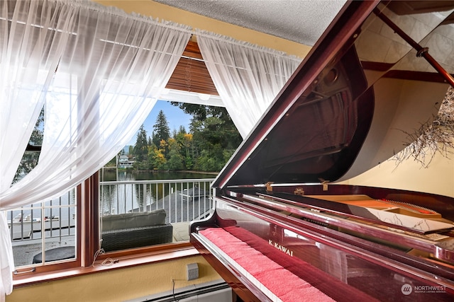 miscellaneous room with a water view and a textured ceiling