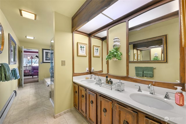 bathroom with a baseboard heating unit, vanity, tile patterned floors, and walk in shower