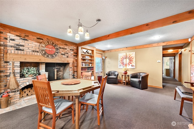 carpeted dining area with a textured ceiling, a chandelier, built in features, a brick fireplace, and beam ceiling