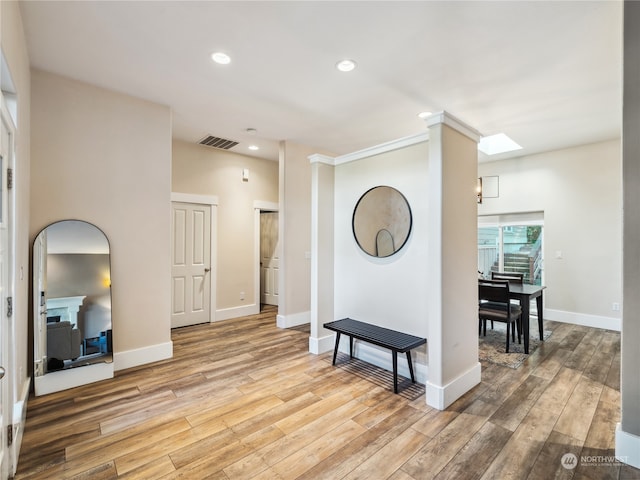 interior space with light hardwood / wood-style floors and ornamental molding