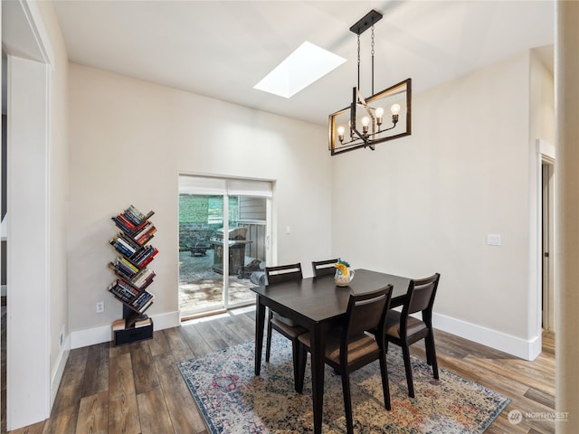 dining room featuring a skylight, dark hardwood / wood-style flooring, and a notable chandelier