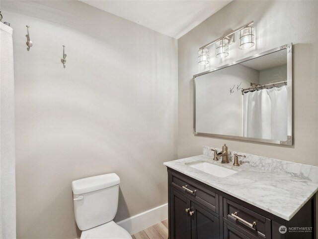 bathroom with hardwood / wood-style floors, vanity, and toilet