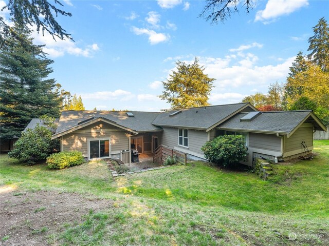 rear view of property featuring a yard