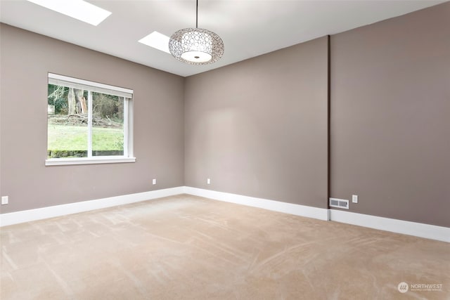 unfurnished room featuring carpet flooring and a skylight