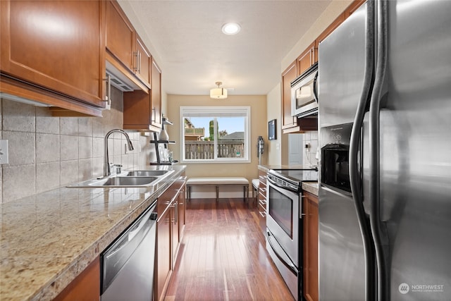 kitchen featuring backsplash, appliances with stainless steel finishes, dark hardwood / wood-style flooring, and sink