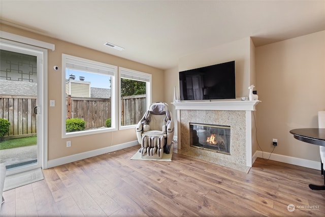 unfurnished room featuring a fireplace and light hardwood / wood-style floors