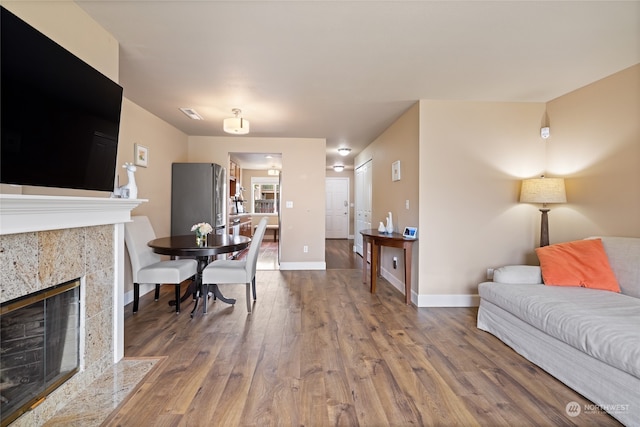 living room featuring a high end fireplace and hardwood / wood-style floors