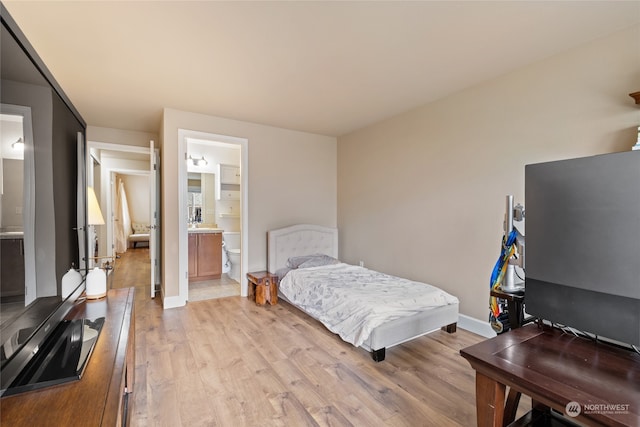 bedroom with light hardwood / wood-style flooring and connected bathroom