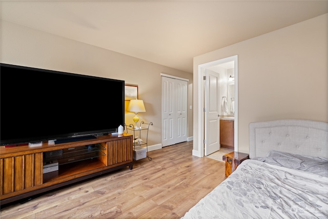 bedroom featuring a closet, connected bathroom, and light hardwood / wood-style flooring