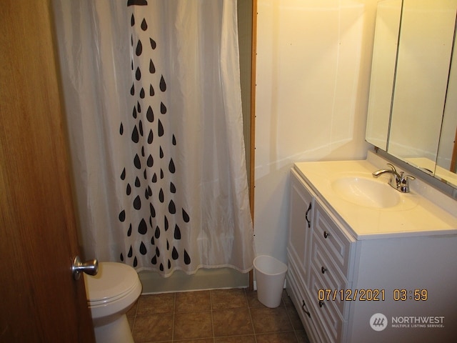 full bathroom featuring tile patterned flooring, vanity, toilet, and shower / bath combo with shower curtain