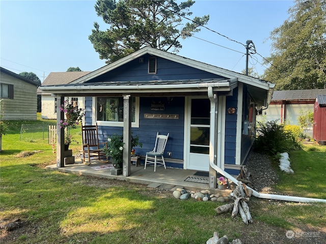 rear view of property featuring a lawn