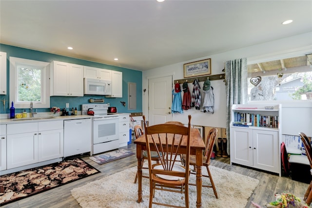 kitchen with sink, white appliances, white cabinets, and light hardwood / wood-style floors