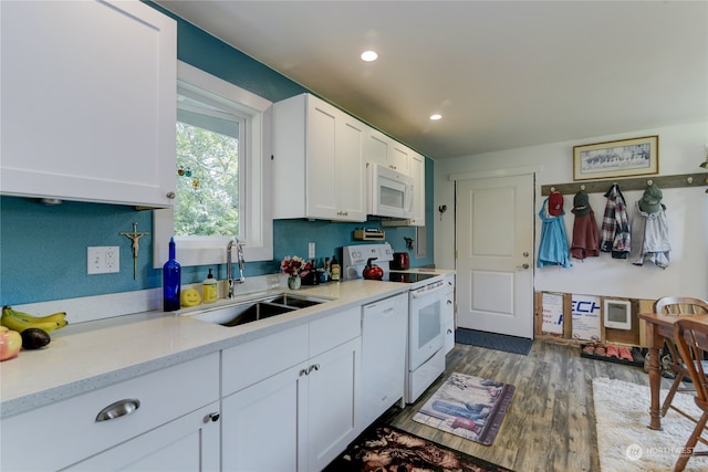 kitchen featuring white cabinetry, white appliances, dark hardwood / wood-style flooring, and sink