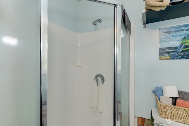 bathroom with toilet and a shower with door