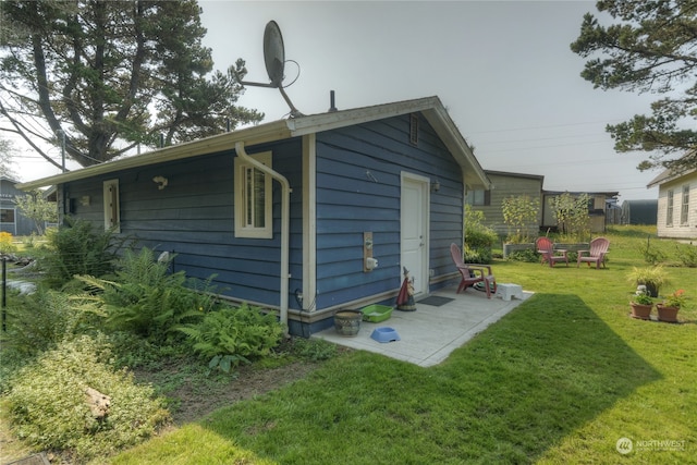 view of home's exterior with a fire pit and a lawn