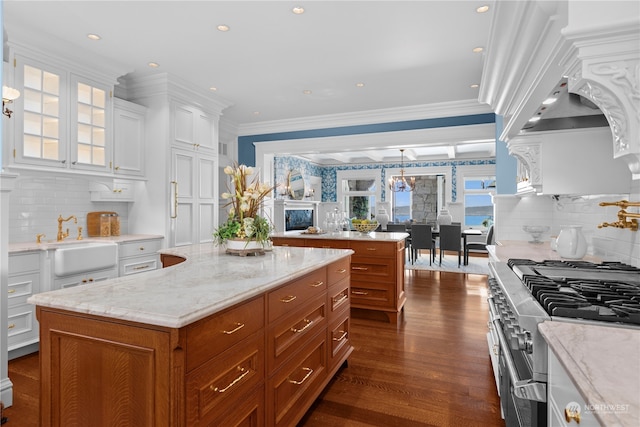 kitchen featuring white cabinets, range with two ovens, and decorative backsplash