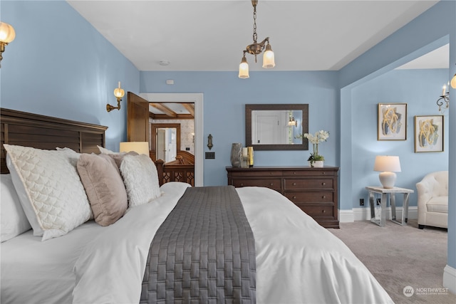 carpeted bedroom with a notable chandelier