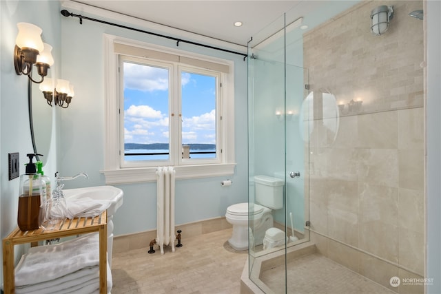 bathroom with a water view, tile patterned floors, a shower with shower door, vanity, and toilet