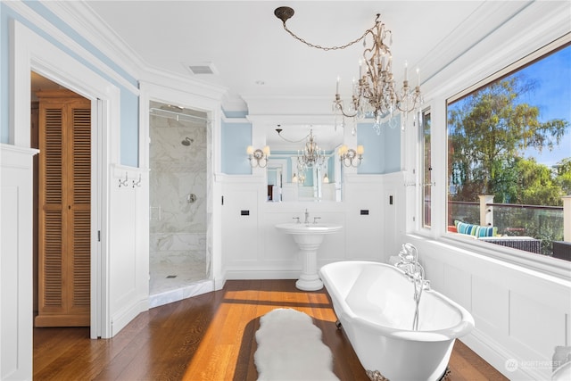 bathroom featuring plus walk in shower, a notable chandelier, hardwood / wood-style flooring, and crown molding