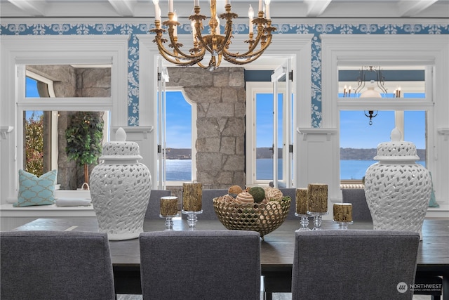 dining space with wood-type flooring, beamed ceiling, a water view, and a wealth of natural light