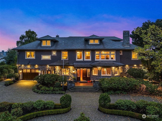 back house at dusk with a garage