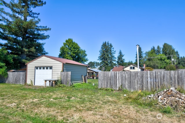 view of yard featuring a garage and an outbuilding