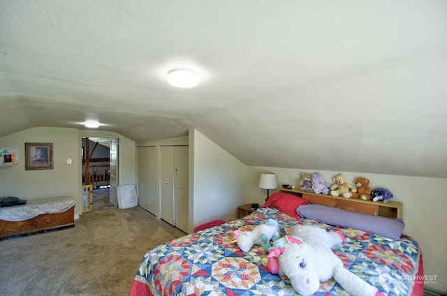 carpeted bedroom with vaulted ceiling, a textured ceiling, and a closet