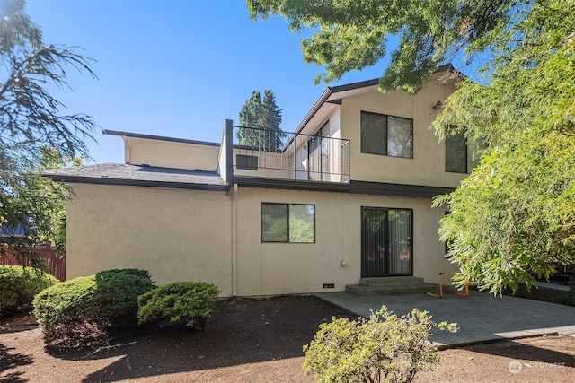 rear view of house with a balcony and a patio