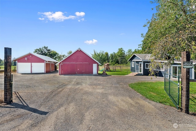 single story home with a garage, a front lawn, and an outdoor structure