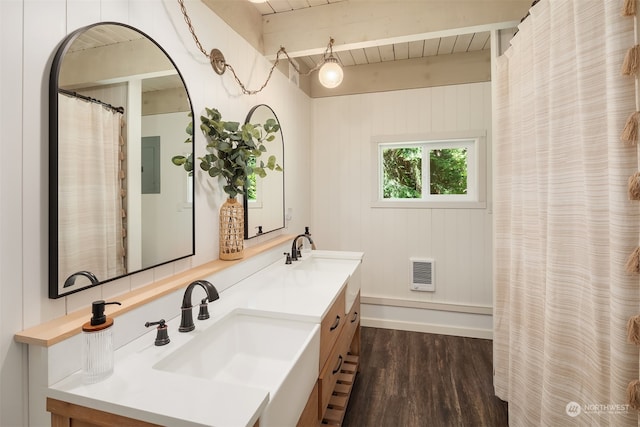 bathroom with wood-type flooring, wooden walls, heating unit, and vanity