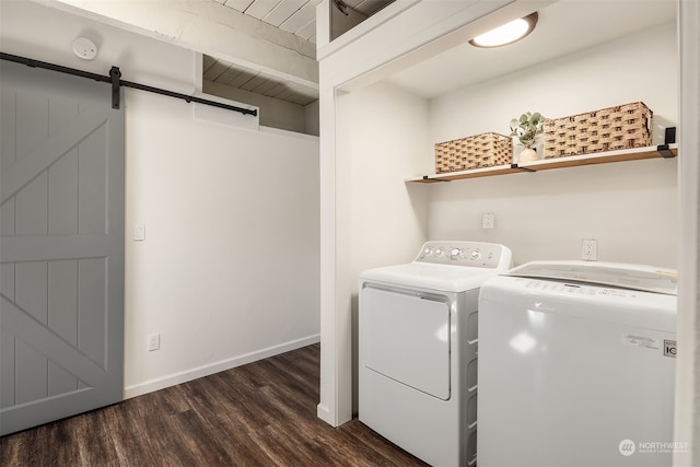 laundry room with dark wood-type flooring, washer and dryer, and a barn door