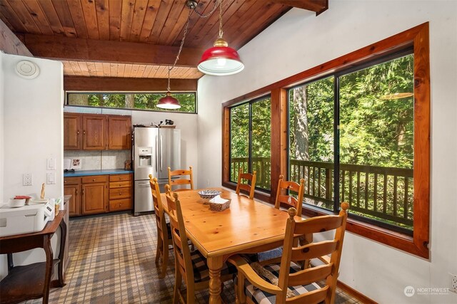 dining space featuring wood ceiling, a wealth of natural light, and vaulted ceiling with beams