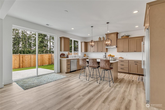 kitchen with visible vents, light countertops, dishwasher, light wood finished floors, and a kitchen bar