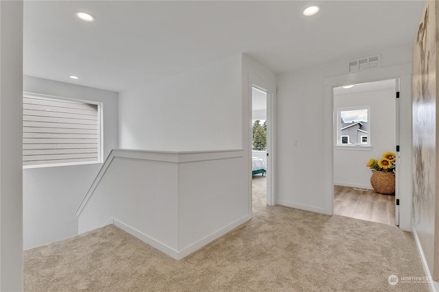 hall featuring an upstairs landing, recessed lighting, visible vents, and carpet flooring