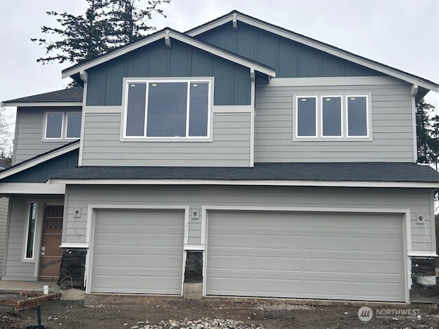 16220 76th Avenue Ct E, Puyallup, WA 98375 - view of front of house featuring a garage, board and batten siding, roof with shingles, and dirt driveway