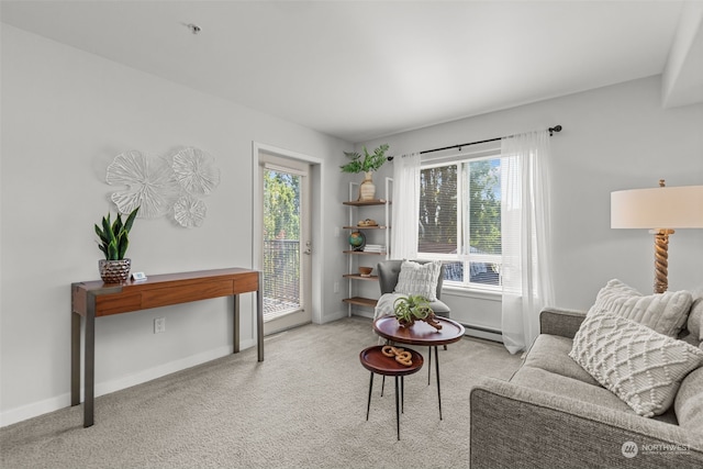 living area featuring a baseboard heating unit and light carpet