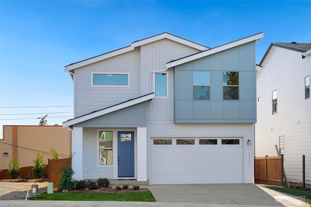 view of front of property featuring concrete driveway, an attached garage, and fence