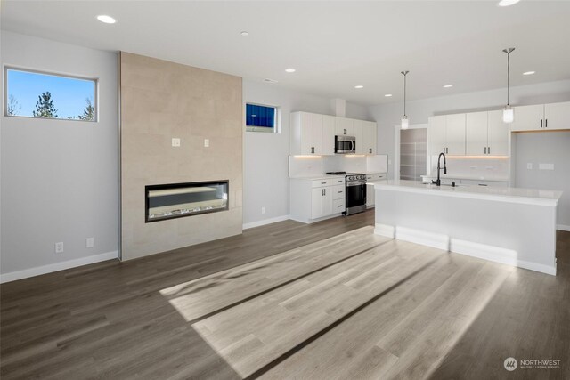 kitchen featuring white cabinets, stainless steel appliances, light countertops, and wood finished floors