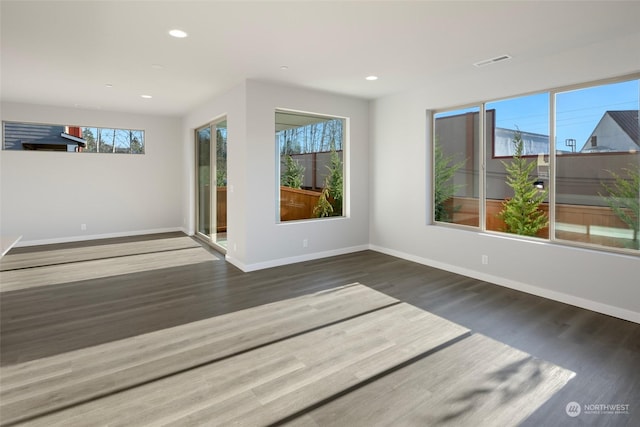 spare room with recessed lighting, wood finished floors, visible vents, and baseboards